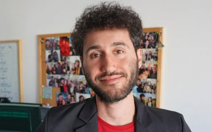 Nicolás Martorell in front of a corkboard covered in photos